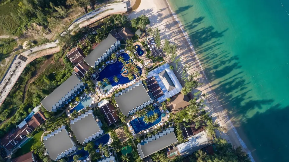Sunwing Bangtao Beach set fra luften med hotelbygninger, pools og sandstrand.