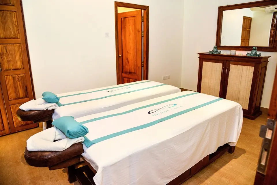 Behandlingsrum med to massagebrikse og turkise tekstiler på Goldi Sands Hotel