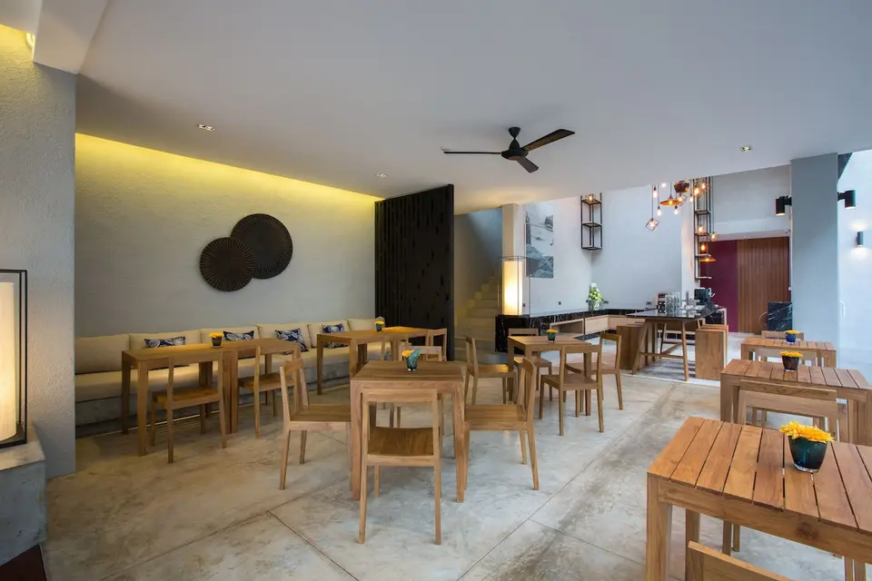 Restaurant med træborde, træstole og lang polstret bænk