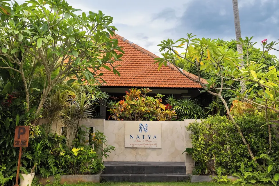 Natya Hotel Tanah Lots indgangsskilt omgivet af tropiske planter