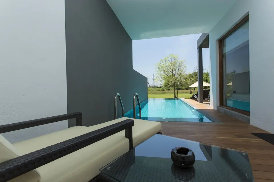 Lille pool ved en overdækket terrasse med sofa og glasbord på Aliya Resort.