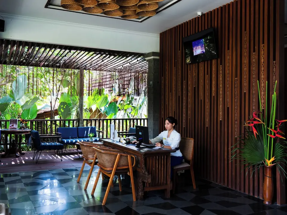 Reception med trædisk og siddeplads mod haven på Natya Hotel Tanah Lot