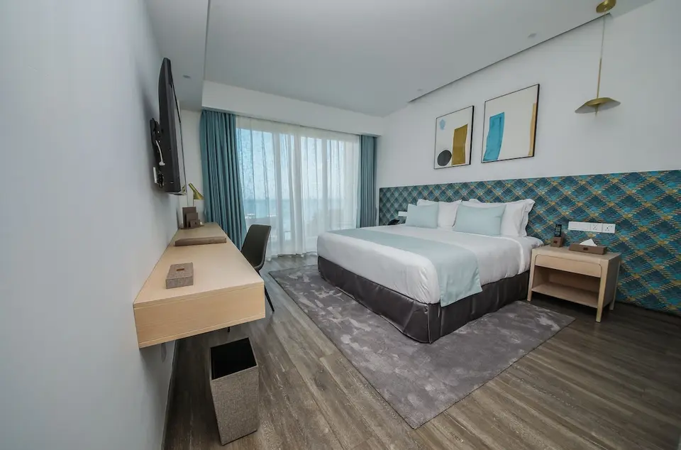 Dobbeltværelse med skrivebord, mønstret sengegavl og lyseblå tekstiler på Ocean V Hotel