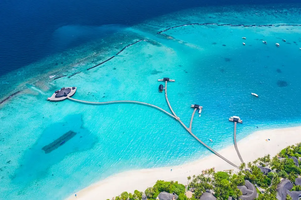 Luftfoto af badebroer og pavilloner ud for stranden på Sun Siyam Iru Fushi