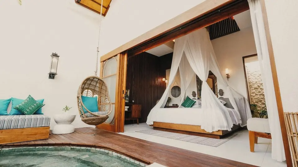 Himmelseng med åbne glasdøre mod poolterrasse på Natya Hotel Tanah Lot