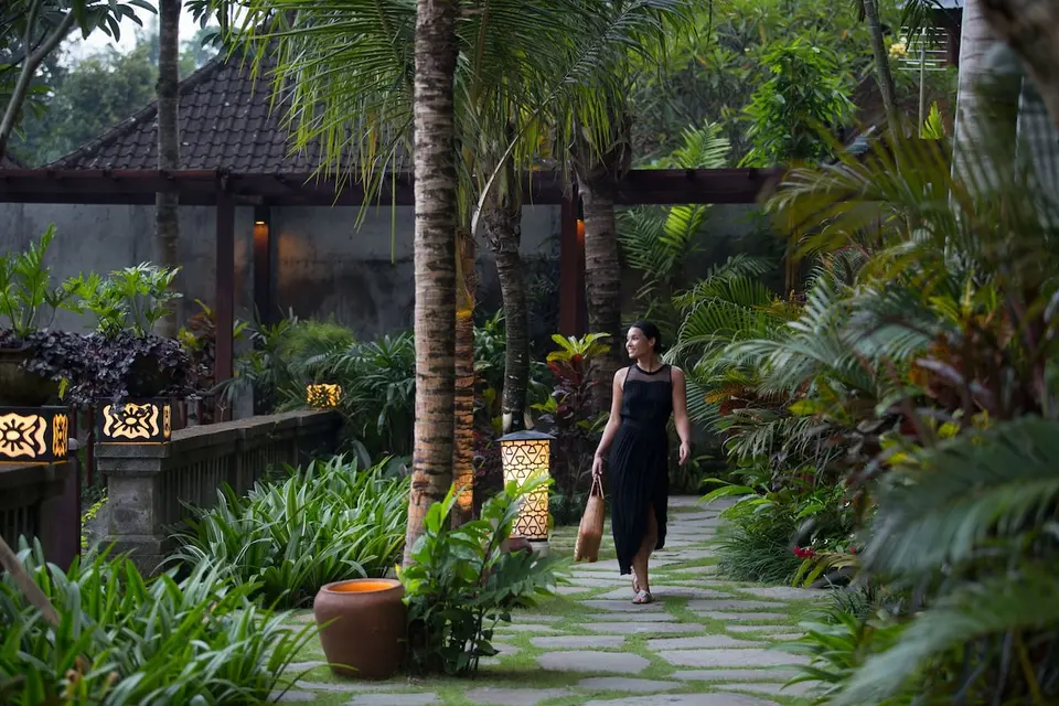 Havesti mellem palmer og hotelbygninger på Adiwana Resort Jembawan