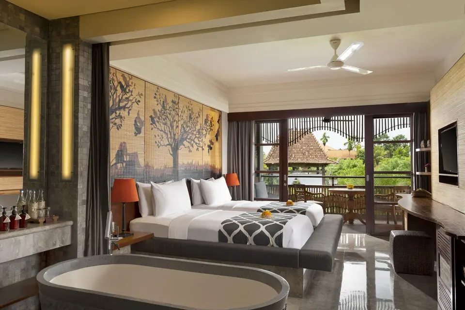 Værelse med to senge, fritstående badekar og balkon på Alaya Resort Ubud.