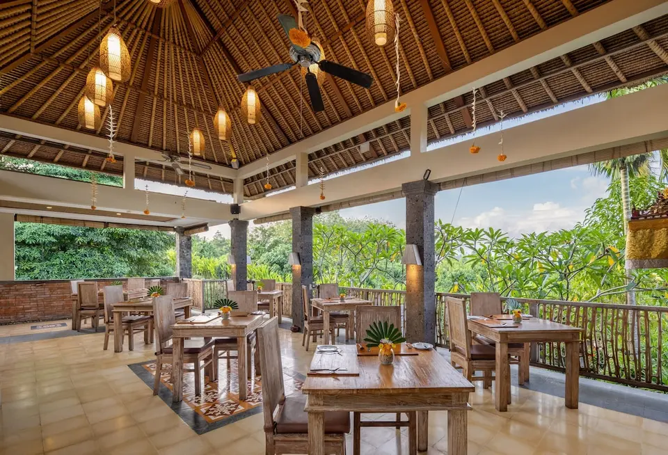 Åben restaurant med udsigt til grønne omgivelser på The Alena Resort