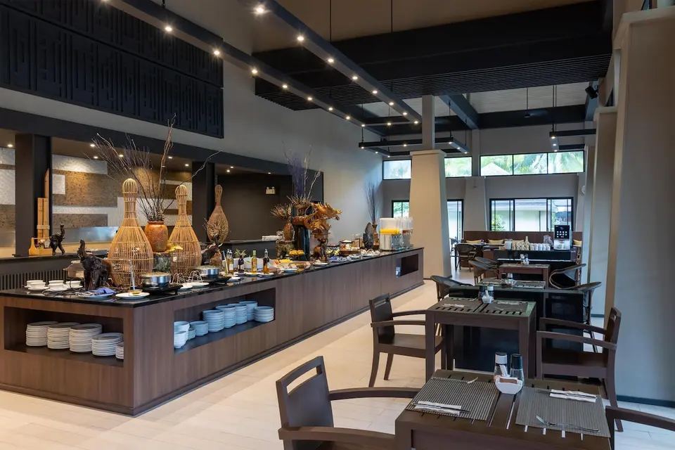 Restaurant med buffetdisk og dækkede borde.