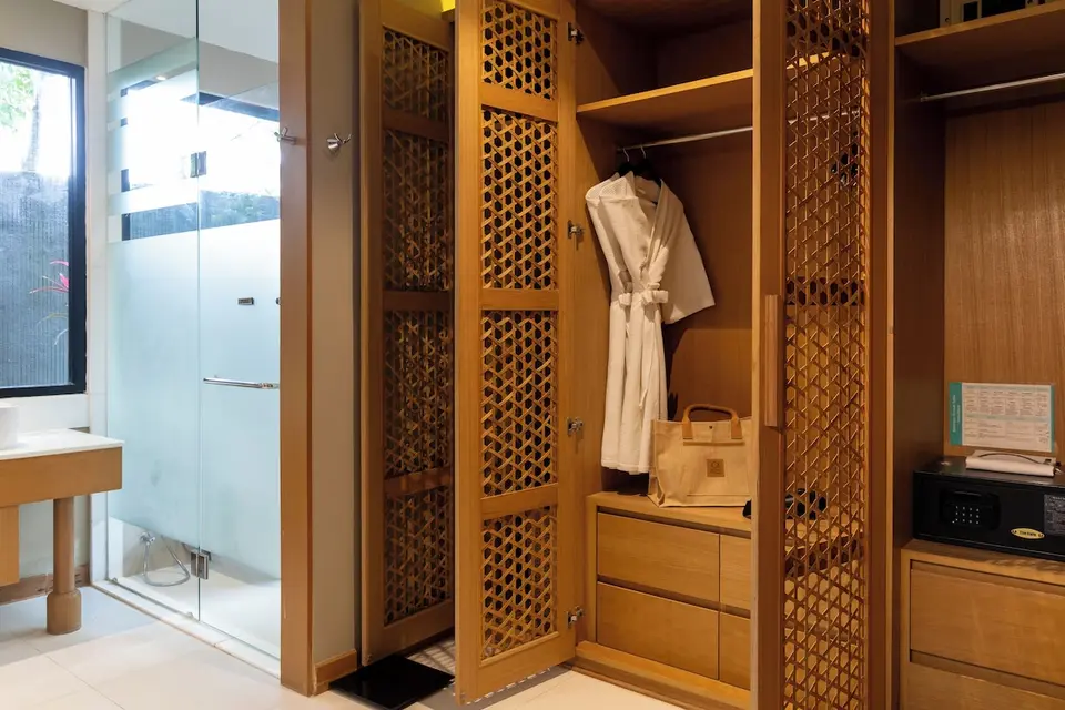 Garderobe med badekåbe og værdiboks ved badeværelset.