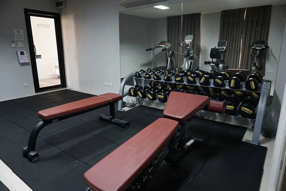 Fitnessrum med håndvægte, træningsbænke og konditionsmaskiner