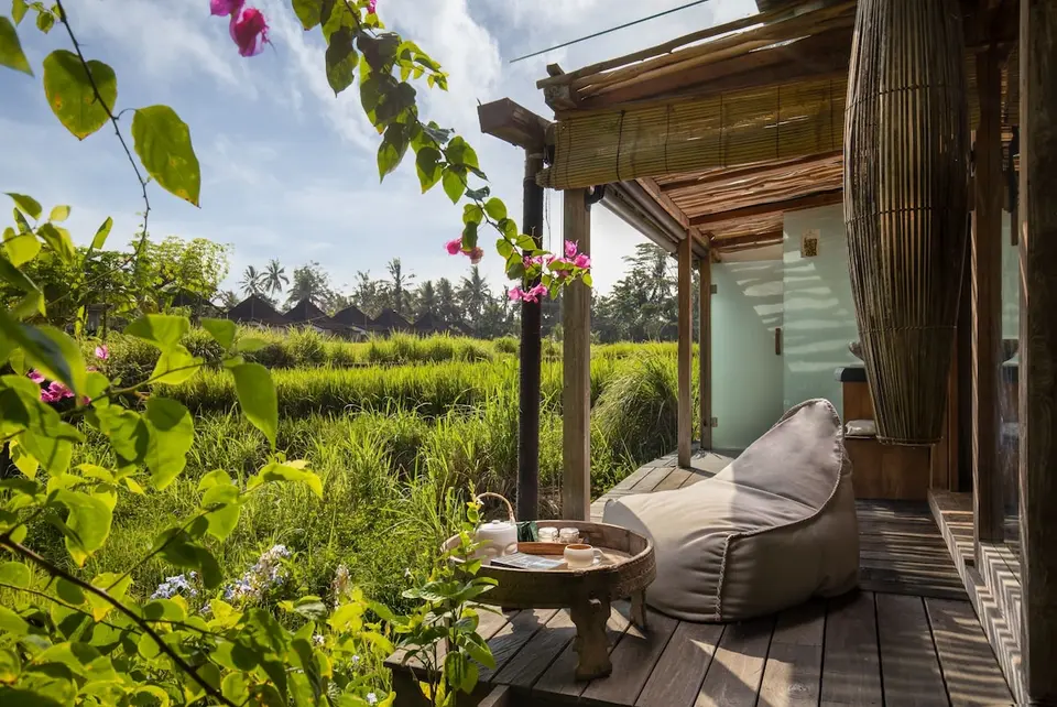 Terrasse med hvilestol og udsigt til rismark på Blue Karma Dijiwa Ubud.
