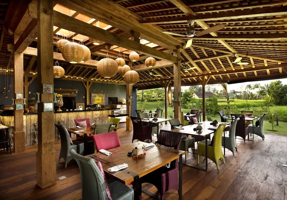 Åben restaurant med træborde og grøn udsigt på Blue Karma Dijiwa Ubud.
