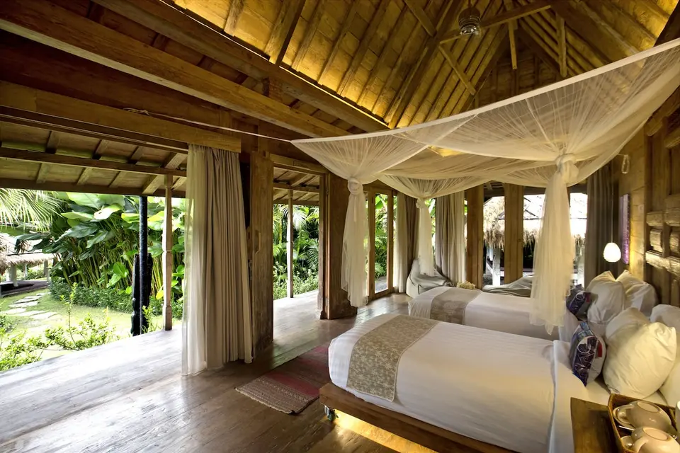 Værelse med to enkeltsenge under myggenet på Blue Karma Dijiwa Ubud.