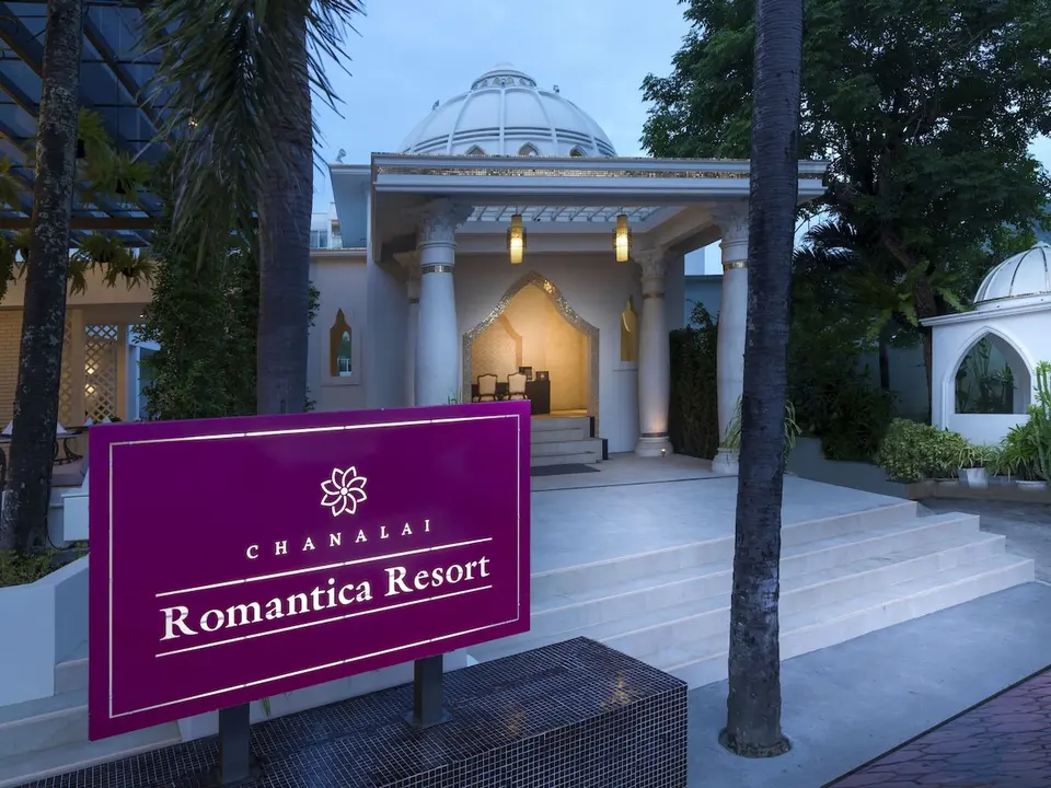 Indgang til Chanalai Romantica Resort med hotelskilt, trappe og hvid kuppel.