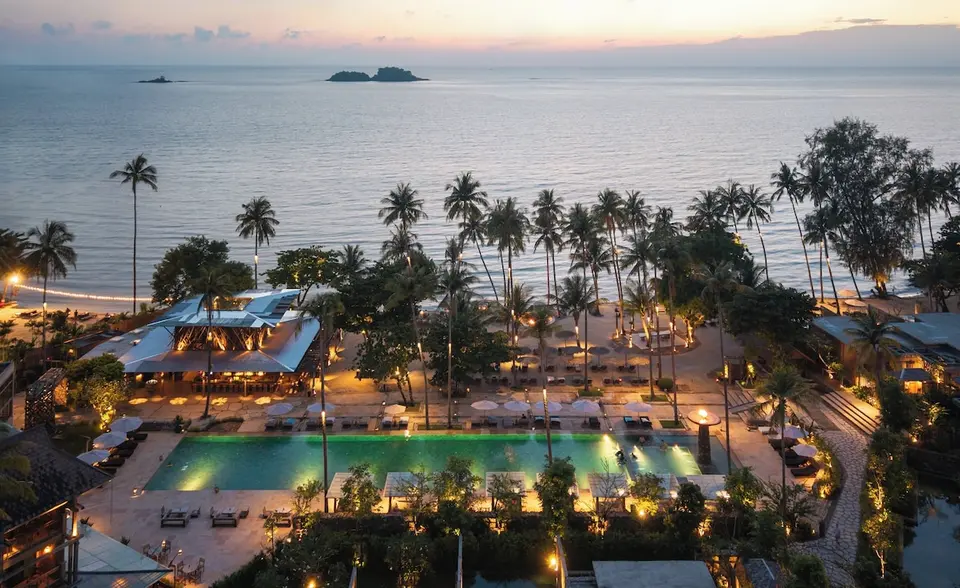 Pool, palmer og strand set ovenfra i aftenlys på Dinso Ko Chang