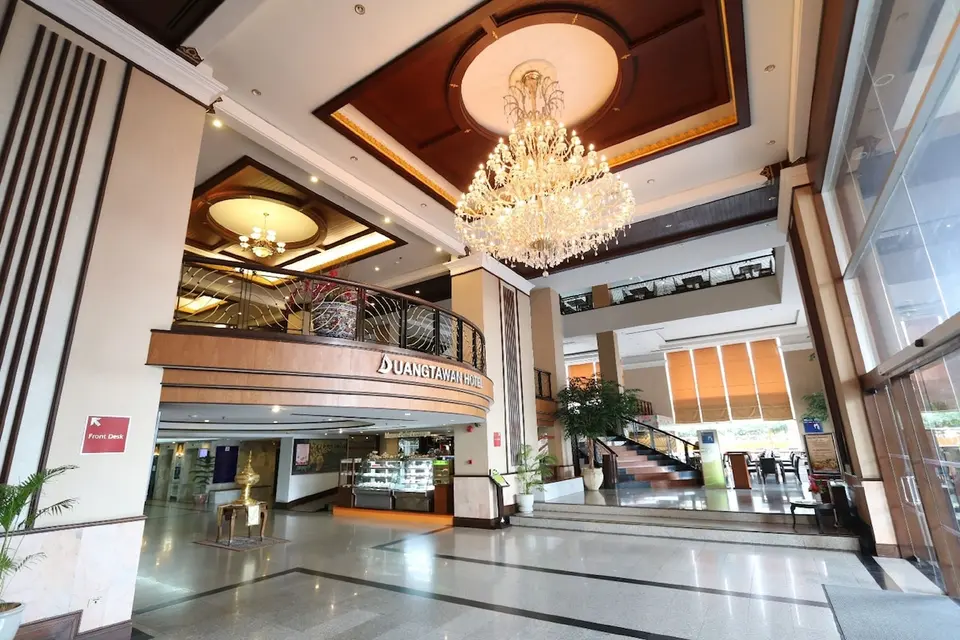 Lobby med lysekroner og hotellets navneskilt på Duangtawan Hotel Chiang Mai.
