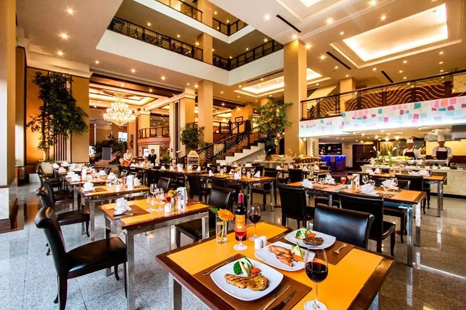 Restaurant med dækkede borde og højt til loftet på Duangtawan Hotel Chiang Mai.