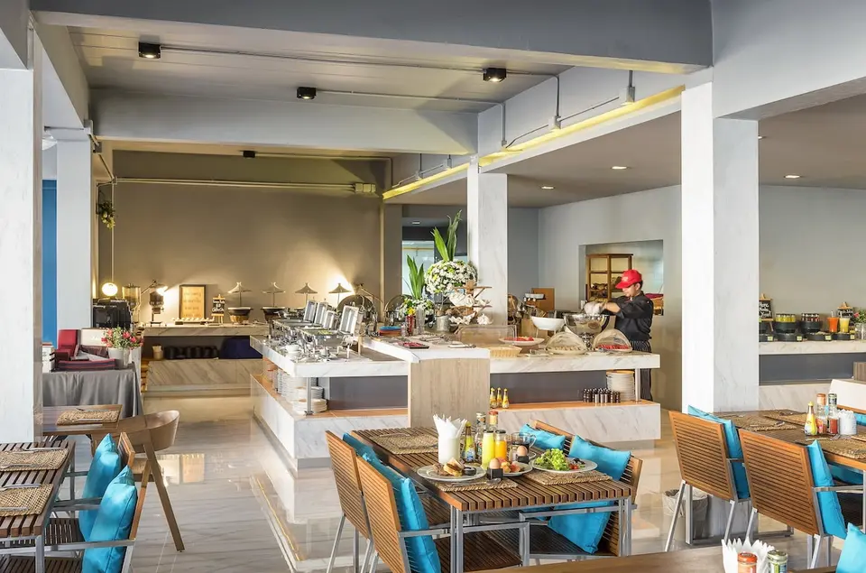 Restaurant med buffet, kok og spisepladser med blå puder på Idyllic Concept Resort.