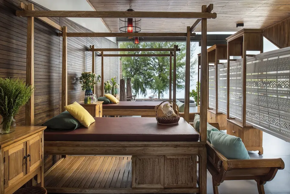 Overdækket spaområde med trælejer, puder og afskærmninger på Idyllic Concept Resort.