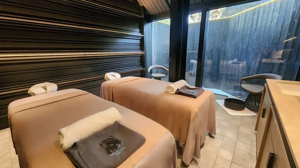 Behandlingsrum med to massagebrikse og store vinduer på Idyllic Concept Resort.