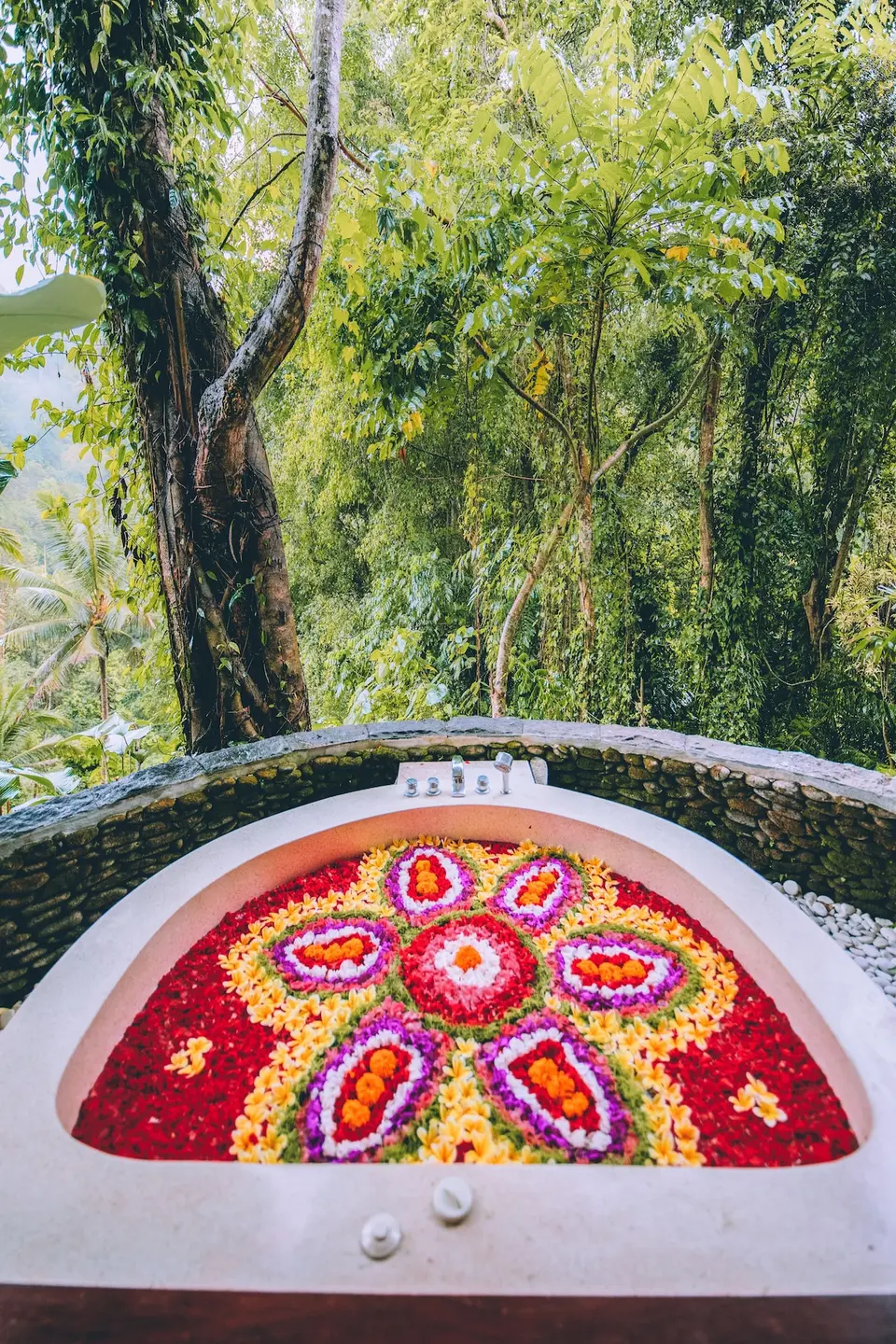 Udendørs badekar med blomster og grønne omgivelser på Jannata Resort & Spa.