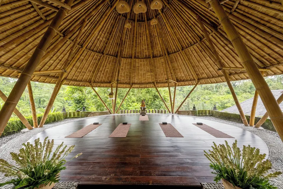 Åben yogapavillon med måtter og udsigt til grønne omgivelser på Jannata Resort & Spa.