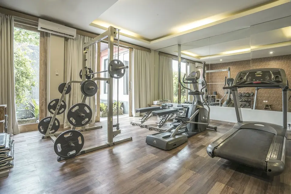 Fitnessrum med løbebånd, træningsbænk og vægte hos KajaNe Yangloni