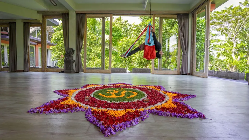 Aktivitetsrum med yogahængekøje og blomsterdekoration hos KajaNe Yangloni