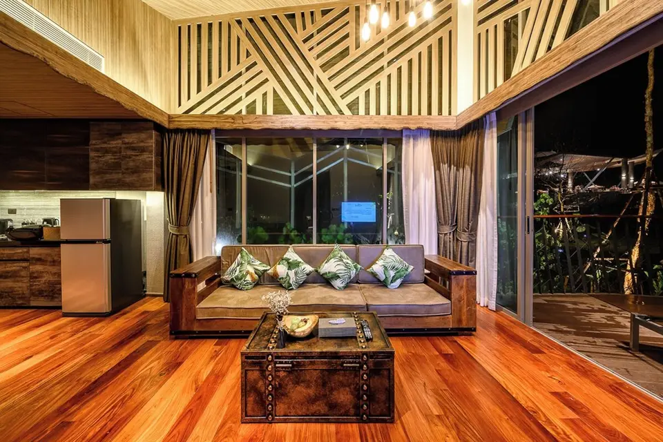 Opholdsrum med sofa, tekøkken og højt loft på Kalima Resort & Villas Khao Lak