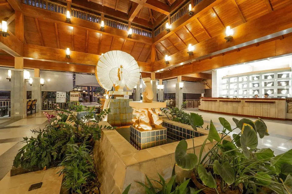Lobby på Khaolak Merlin Resort med højt træloft, reception og dekorativt vandbassin med skulpturer