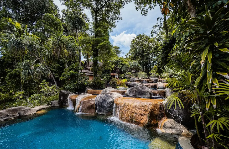Pool på Khaolak Merlin Resort med små vandfald over sten mellem tæt tropisk beplantning