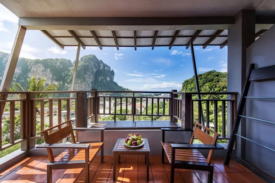 Møbleret balkon med træstole og udsigt mod kalkstensklipper på Krabi Cha Da Resort.