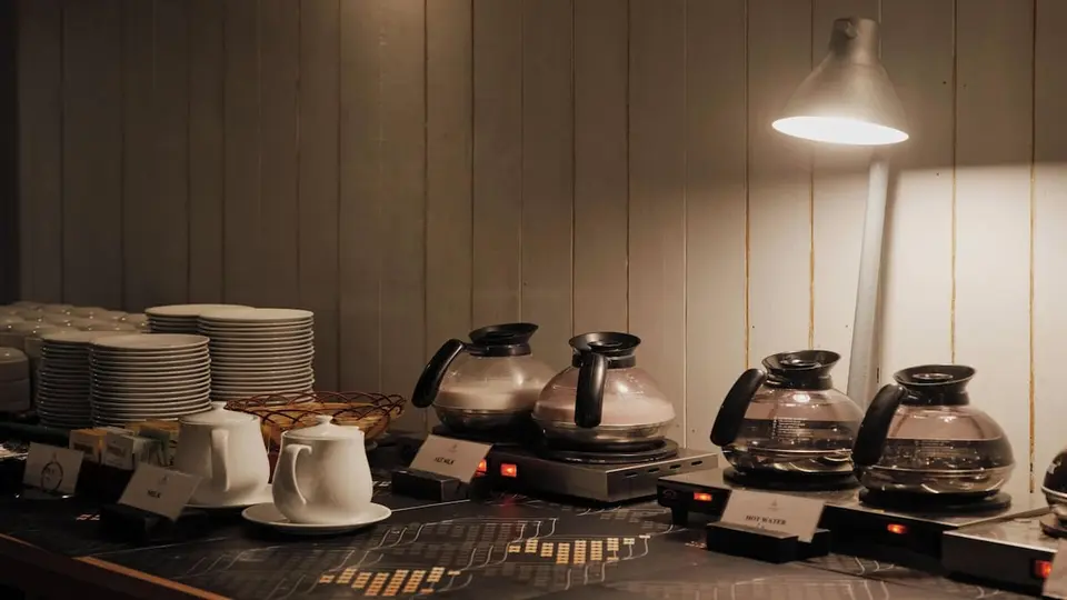 Kaffe- og testation med glaskander, kopper og tallerkener.