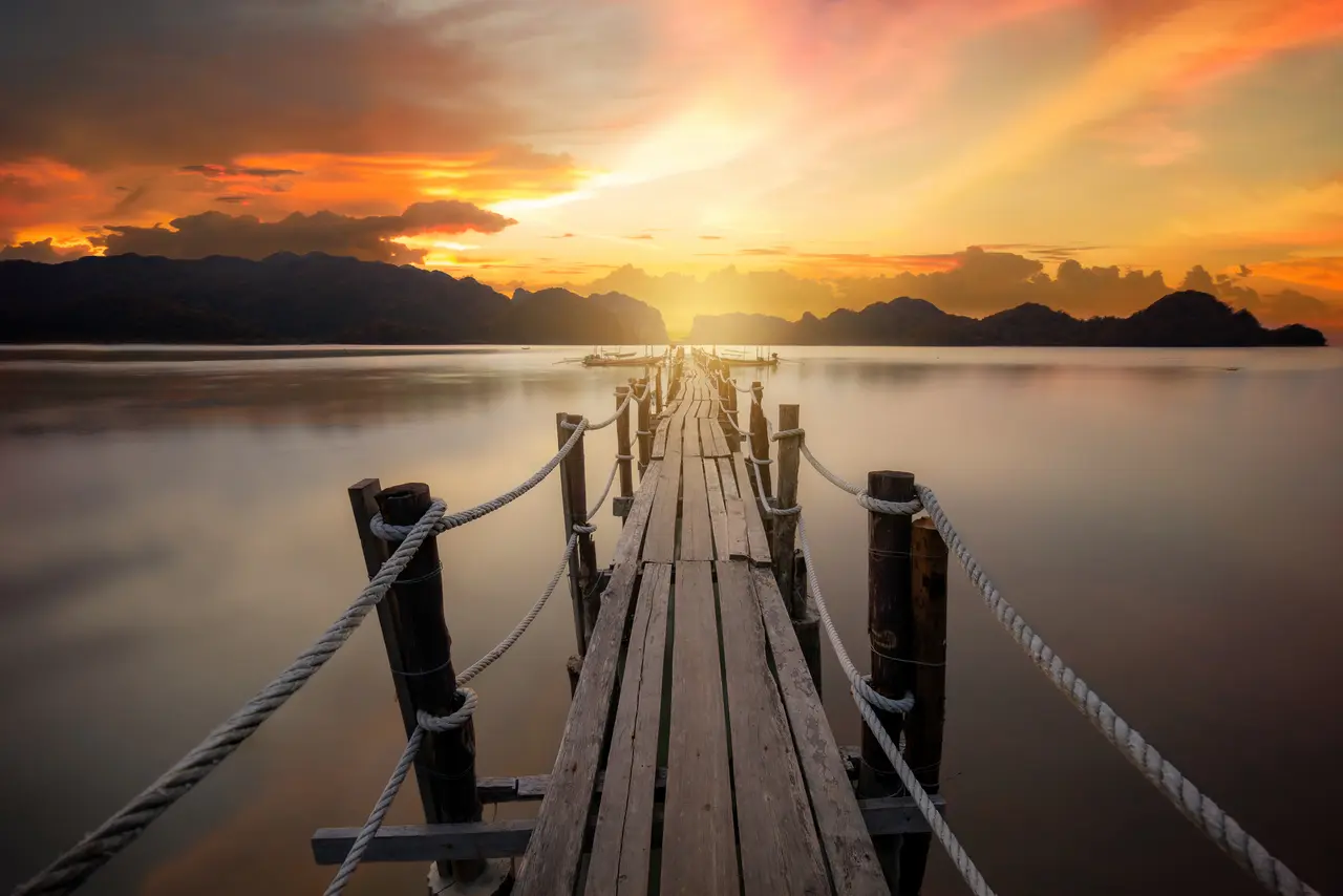 Solnedgang paa badebro ved ao talet ved khanom i thailand