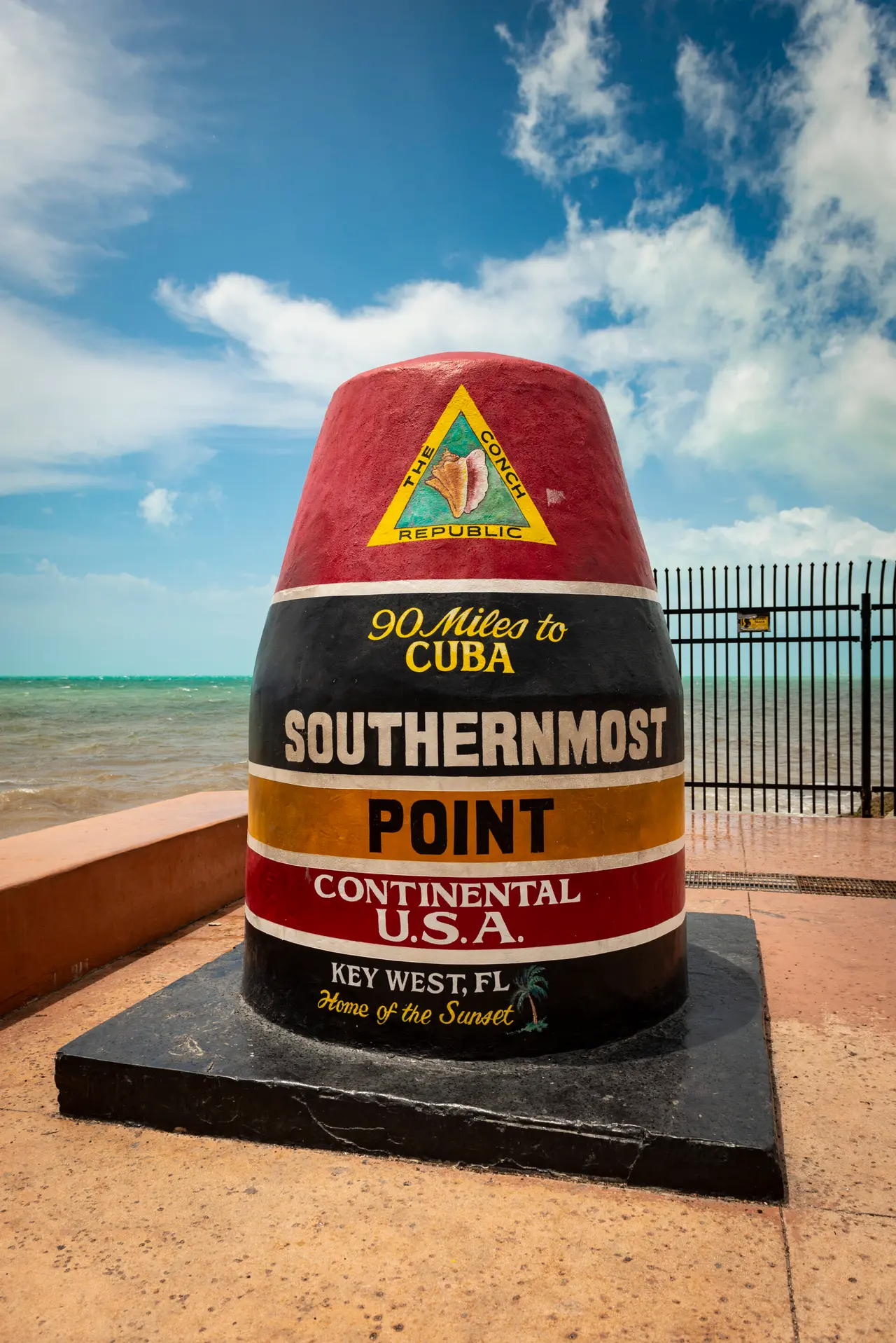 Det farvede Southernmost Point-monument i Key West med havet bagved.