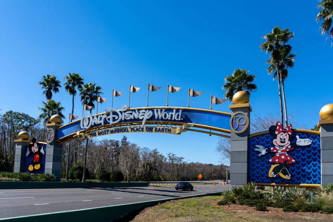 Indkørslen til Walt Disney World med en blå og gylden portal og tegninger af Mickey Mouse og Minnie Mouse.