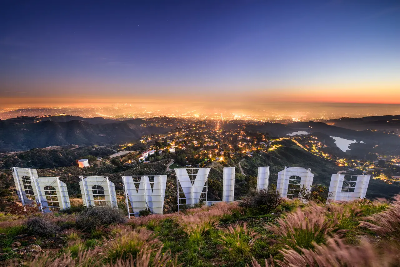 Bagsiden af Hollywood-skiltet med udsigt over bakker og byens lys.
