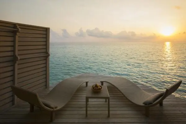Liggestole på en terrasse over havet ved solnedgang på Centara Ras Fushi