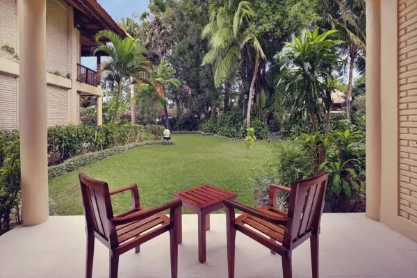 Terrasse med to træstole og udsigt over haven på Mercure Bali Sanur Resort