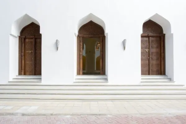 Udskårne trædøre og buede indgange i Park Hyatt Zanzibars hvide facade