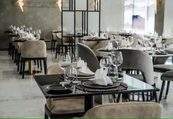 Restaurant med opdækkede borde og polstrede stole på Ocean V Hotel
