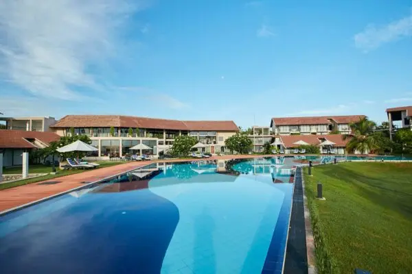 Pool med resortets værelsesbygninger i baggrunden på The Calm Resort & Spa