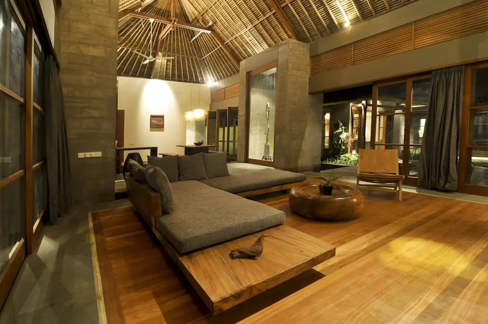 Opholdsrum med hjørnesofa og højt træloft ved Luwak Ubud