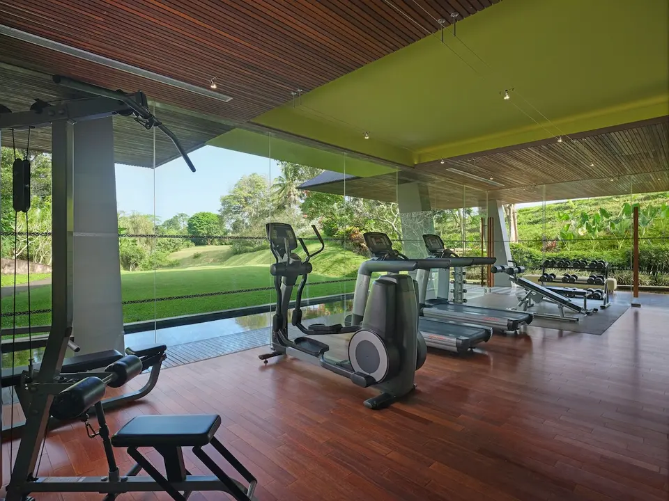 Fitnessrum med træningsmaskiner og store vinduer på Maya Ubud Resort & Spa