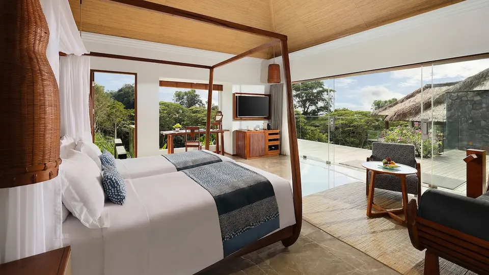 Soveværelse med himmelseng og glasparti mod terrassen på Maya Ubud Resort & Spa