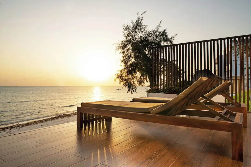 Solnedgang over havet fra terrasse med liggestole på Nungwi Dreams by Mantis