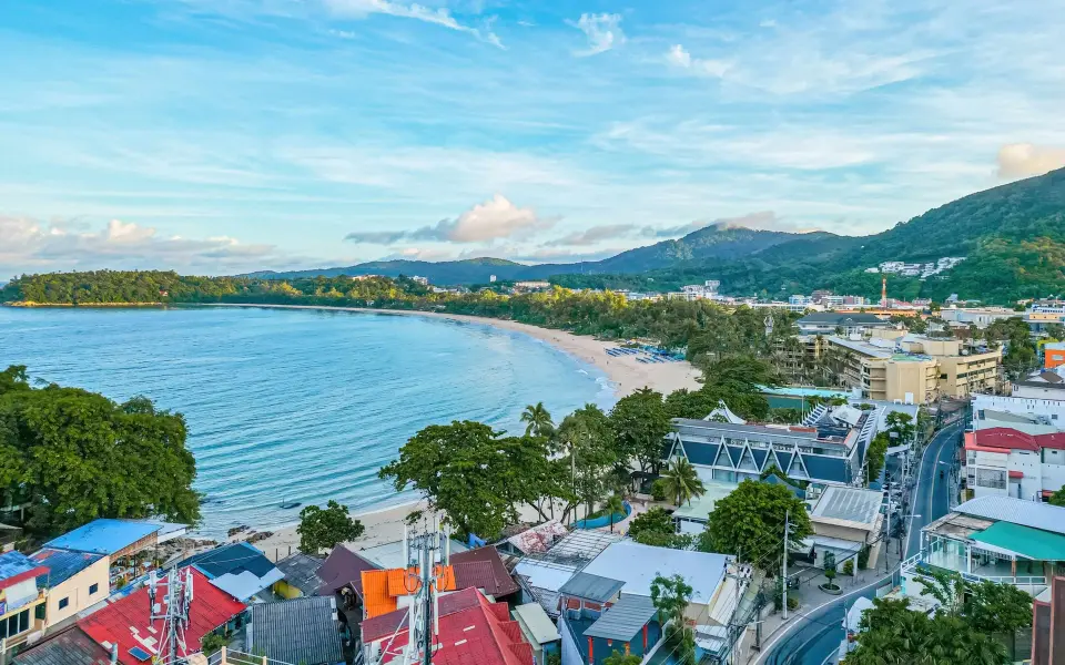 Luftfoto over Kata Beach med bugten, byen og de grønne bakker bag Orchidacea Resort