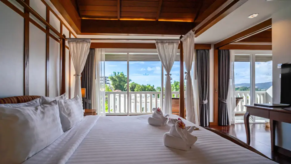 Soveafdeling med træloft og altandør i Premier Suite på Orchidacea Resort