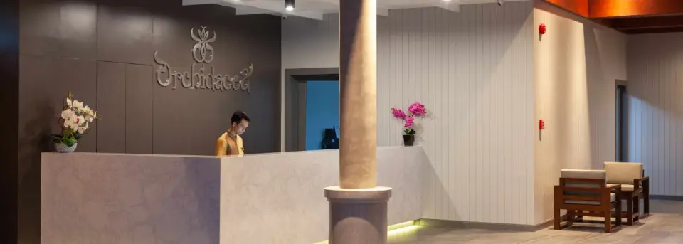 Reception og lobby på Orchidacea Resort med orkideer på skranken